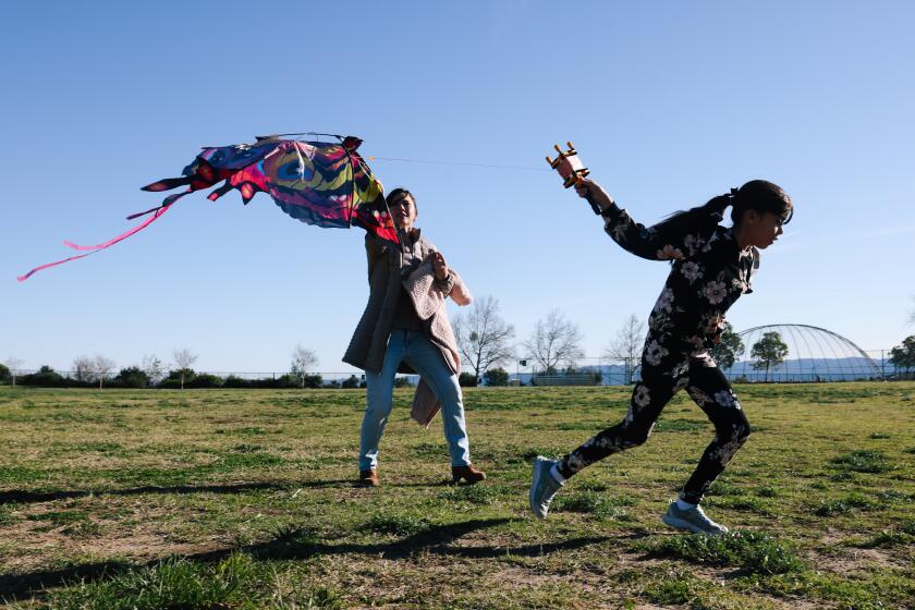 Porter Ranch, CA - January 07: Elizabteh Castillo and her daughter Vianca, 9, work to get a kite off the ground on a windy day at Holleigh Bernson Memorial Park on Sunday, Jan. 7, 2024 in Porter Ranch, CA. (Dania Maxwell / Los Angeles Times)