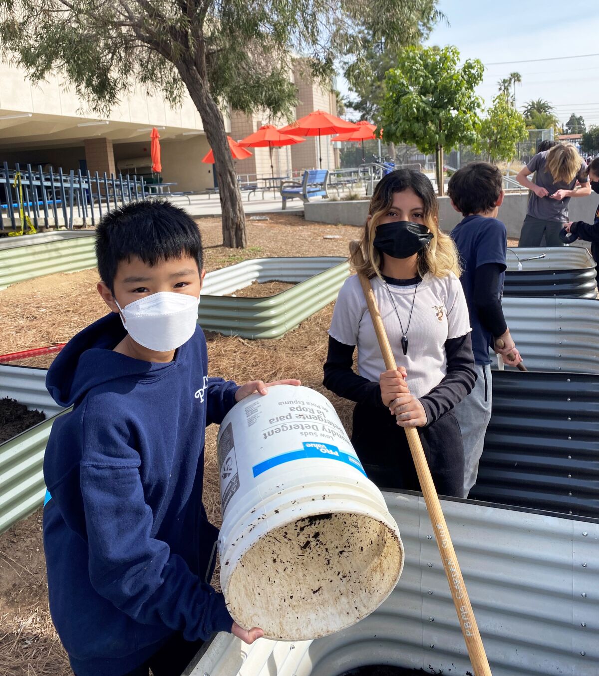 Sixth graders David Peña and Frida Gonzalez filling planter bins.
