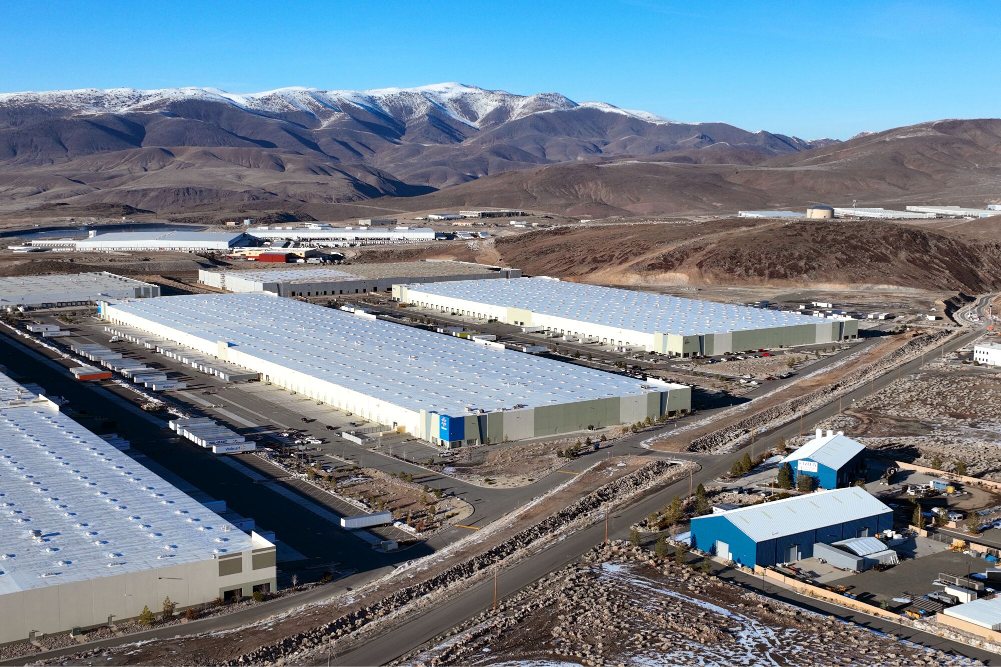 Sprawling warehouses with mountains in the distance.