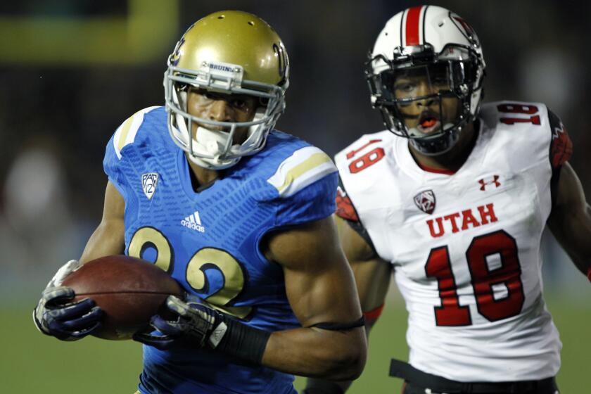 UCLA wide receiver Eldridge Massington catches a pass for a touchdown against Utah defensive back Eric Rowe during a game on Oct. 4, 2014.