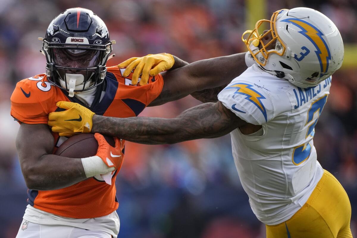Denver Broncos running back Javonte Williams stiff arms Chargers safety Derwin James Jr. during the first half.