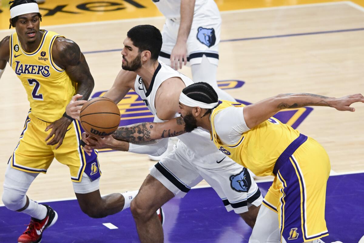 Lakers forward Anthony Davis, right, strips the ball from the grasp of Grizzlies forward Santi Aldama as he drives the lane.