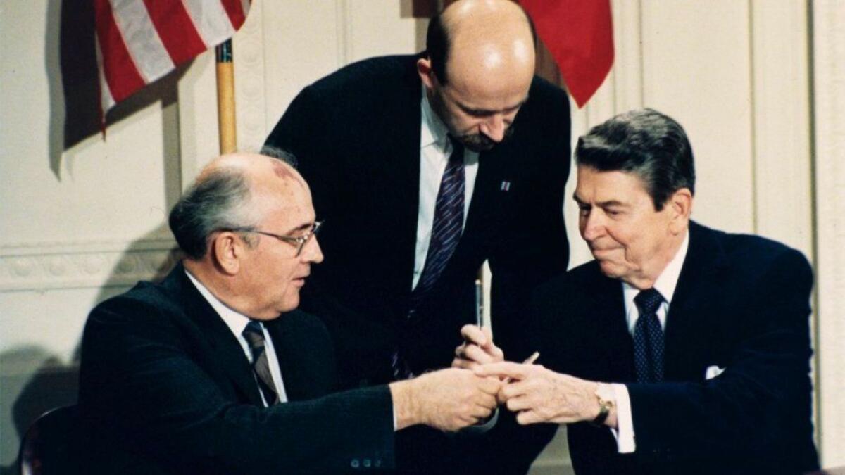 President Reagan and Soviet leader Mikhail Gorbachev, with Gorbachev's translator in the middle, participate in an INF treaty signing ceremony at the White House on Dec. 8, 1987.