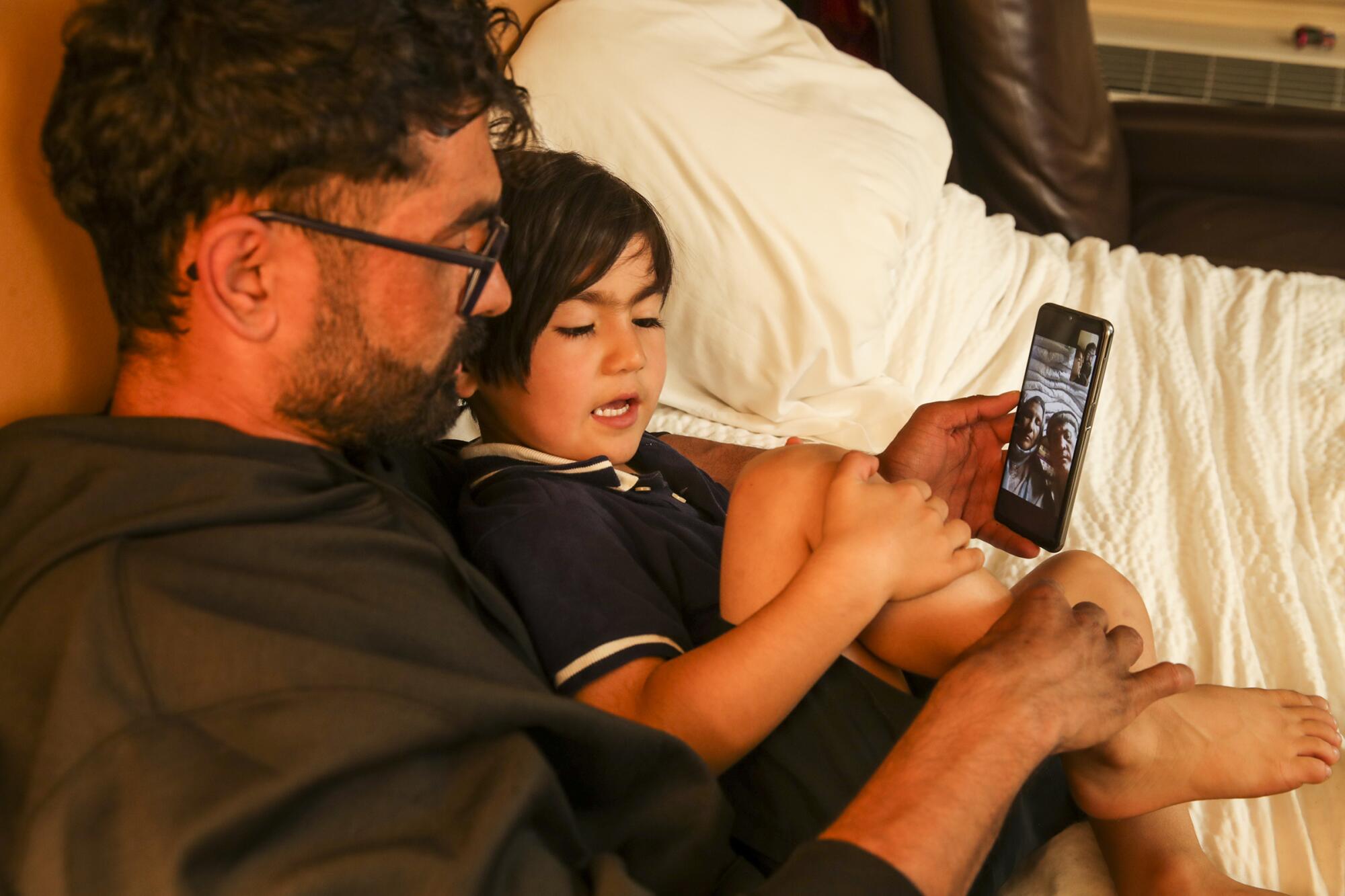 Zabih Khan and his 4-year-old brother Mojib on a video call with their parents in Afghanistan.