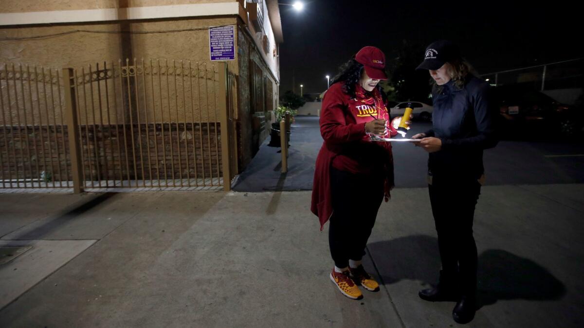 Yasmin Scott-Halcromb, left, and Sarah Mahin consult their map in South Los Angeles during the 2017 homeless count.