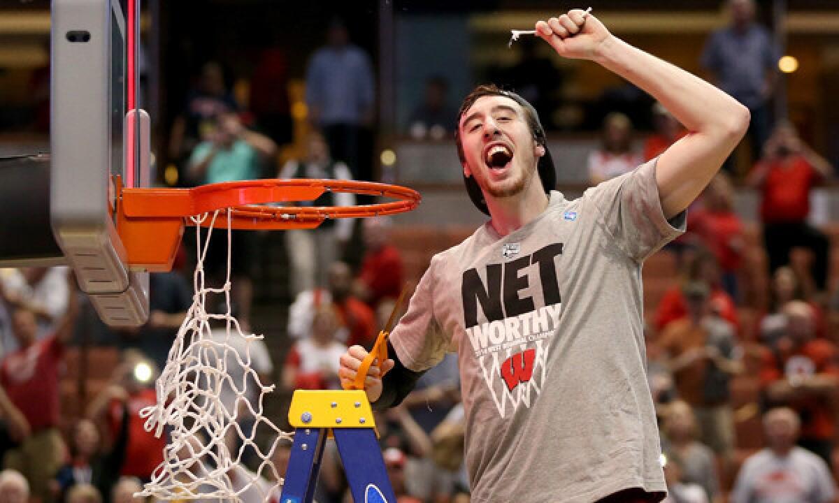 Wisconsin's Frank Kaminsky celebrates as he cuts down the net following the Badgers' 64-63 overtime over top-seeded Arizona on Saturday to advance to the NCAA Final Four. Kaminsky's breakout season has played a key role in pushing Wisconsin to within two victories of claiming its first men's basketball title since 1941.