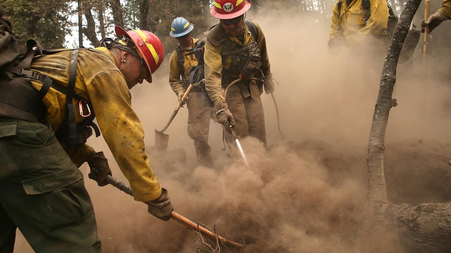 Firefighters mop up hot spots in an area burned by the King fire on Sept. 19 near Pollock Pines, Calif. The King fire is threatening more than 12,000 homes in the forested area about an hour east of Sacramento.