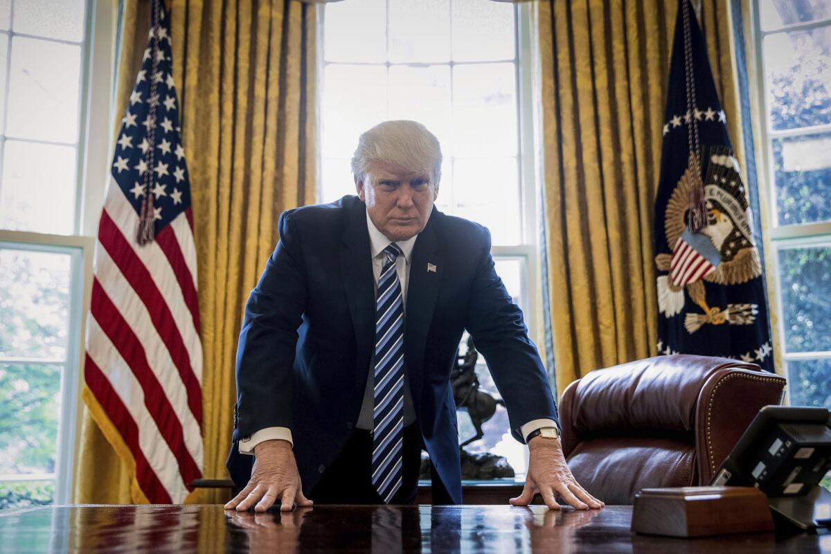 President Trump stands in the Oval Office after an interview with the Associated Press.