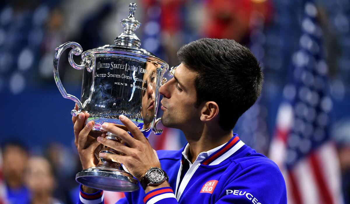 Novak Djokovic kisses his winning trophy after defeating Roger Federer in the U.S. Open Men's singles final match on Sunday.