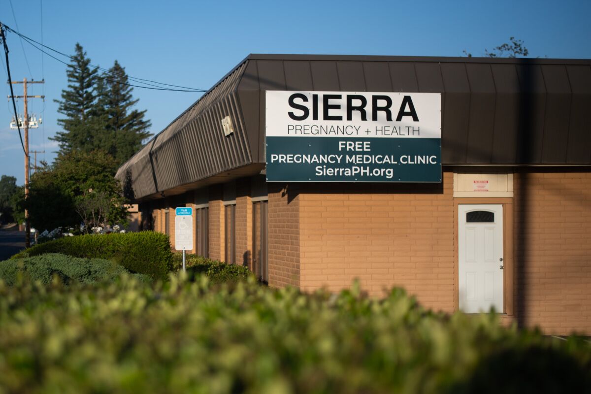 A lawn sign reads "Sierra Pregnancy + Health" and "abortion pill reversal" among other writing