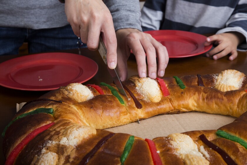 Cutting into the rosca de Reyes.