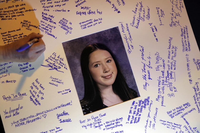 Students sign a card in memory of Gracie Anne Muehlberger, one of two students killed in the shooting this month at Saugus High School in Santa Clarita.