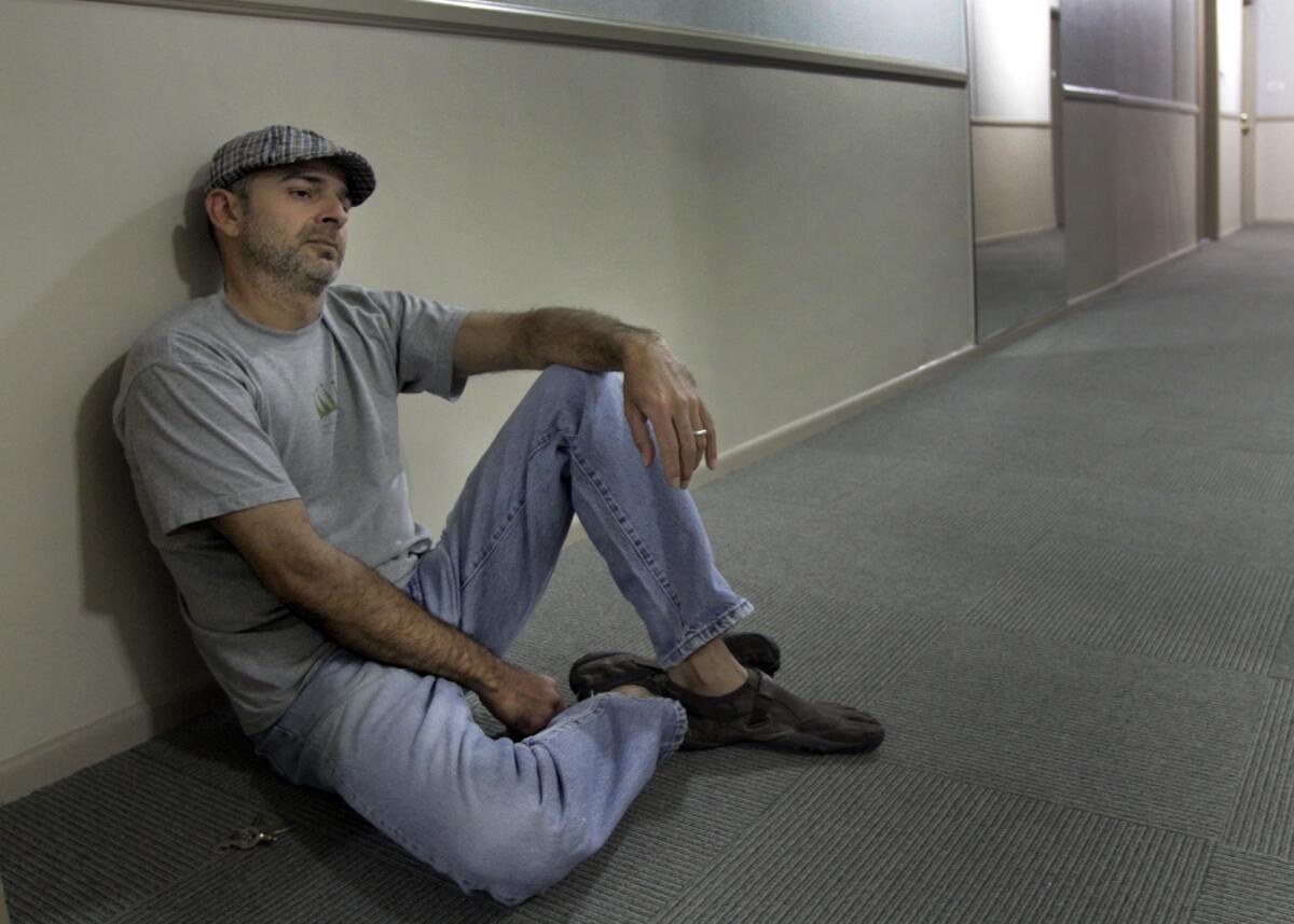 Vyktor Emilio Arce sits in the hallway of the Hollywood apartment where authorities say Nattie Kennebrew attempted to shoot him after killing a handyman.