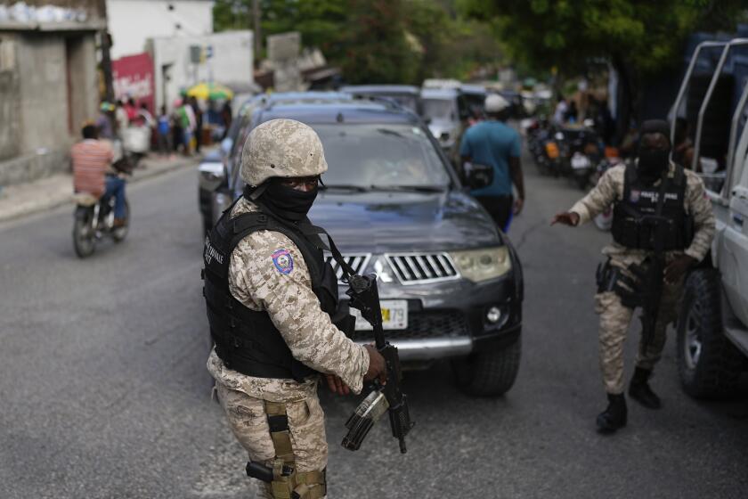 Un grupo de soldados se despliega fuera de la oficina del primer ministro en Puerto Príncipe, Haití, en preparación para el juramento de un consejo de transición encargado de elegir un nuevo primer ministro y gabinete, el jueves 25 de abril de 2024. (AP Foto/Ramon Espinosa)