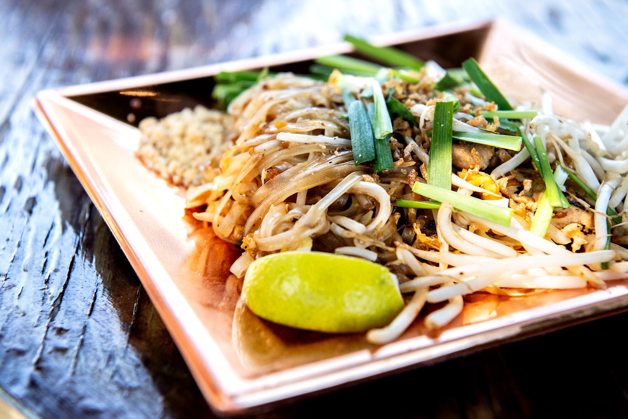 A square tray contains pad thai.