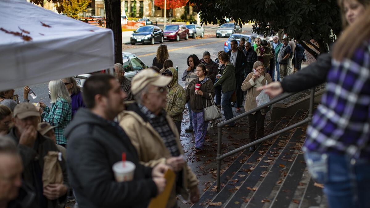 Paradise Camp fire evacuees wait to pick up their mail, which has been forwarded to the Chico post office.