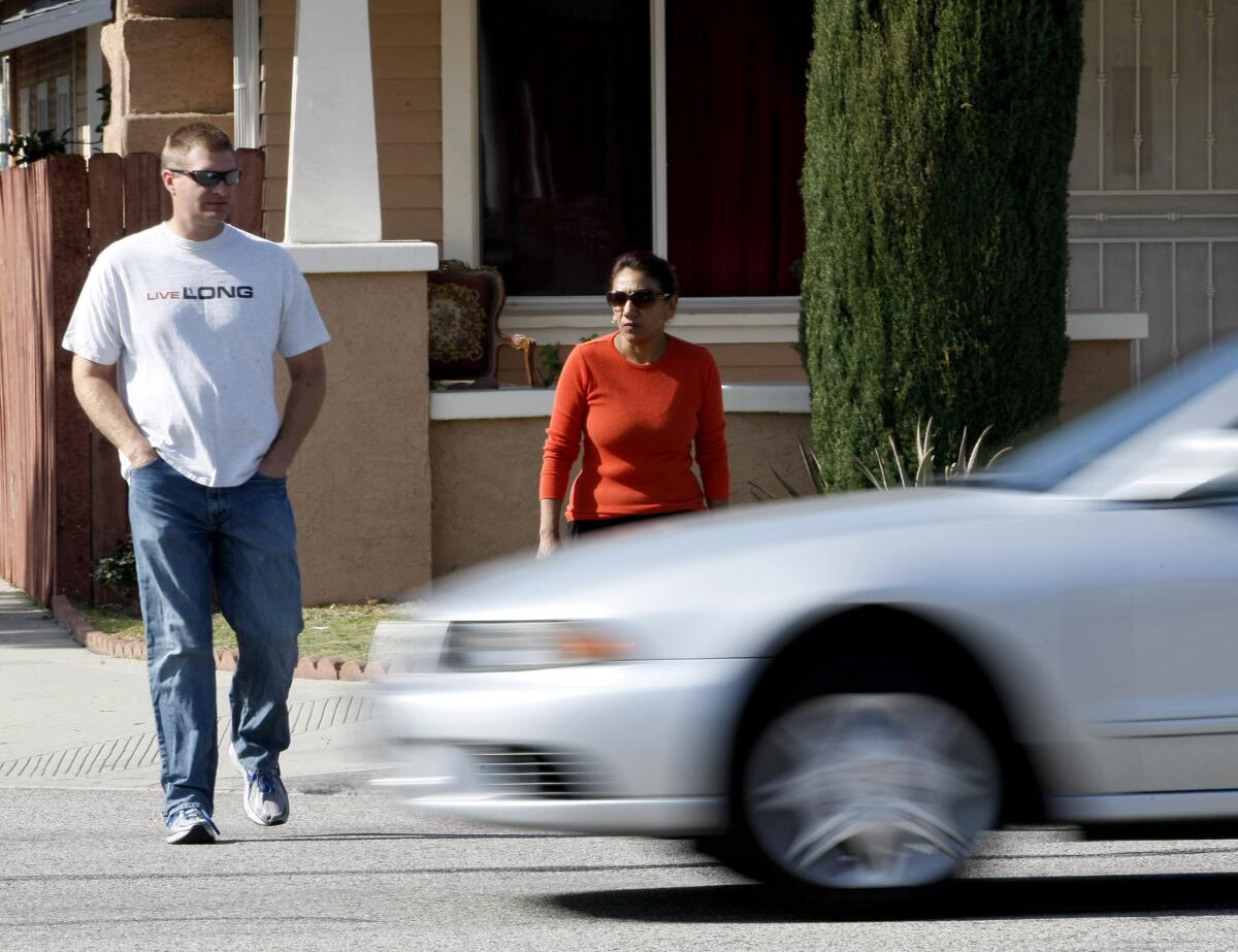 In this Jan. 2014 photo, a driver does not stop for an undercover police officer, left, and a pedestrian, right, during a Glendale Police Department crosswalk pedestrian sting.