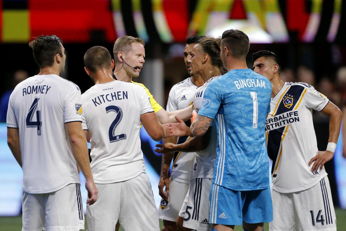 LA Galaxy players argue with the referee over a yellow card called during the second half of the team's MLS soccer match against Atlanta United, Saturday, Aug. 3, 2019, in Atlanta. (AP Photo/Andrea Smith)