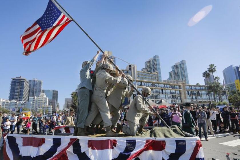 During the 2017 San Diego Veterans Day Parade, members of the Marine Corps ride on the West Coast Drill Instructor Association float as they reenact the iconic World War II raising of the American flag on Iwo Jima.