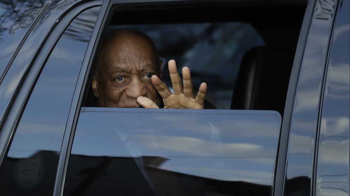 Bill Cosby waves as he leaves the Montgomery County Courthouse in Pennsylvania on Tuesday after proceedings in his sexual assault trial.