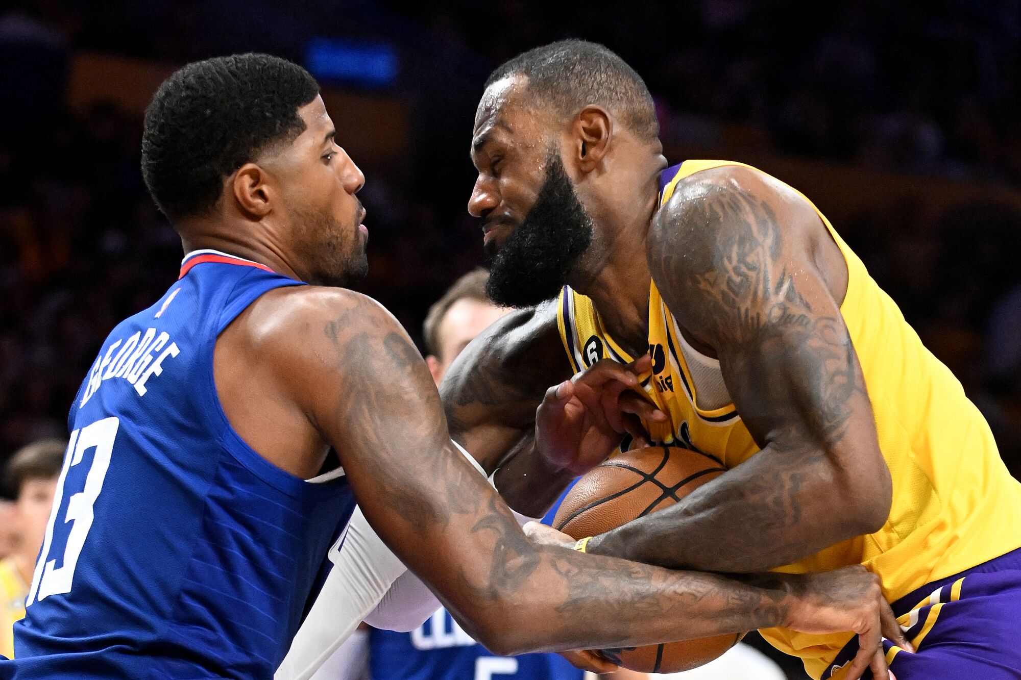 Lakers forward LeBron James gets fouled by Clippers forward Paul George while driving down the lane.