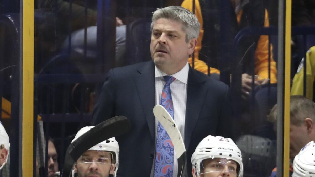 Todd McLellan watches from behind the bench during a game between the Edmonton Oilers and Nashville Predators in 2017.