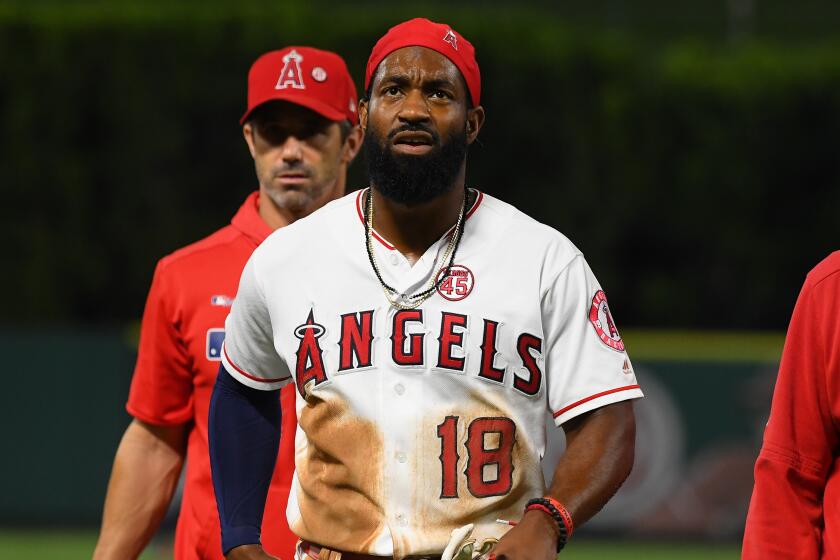 ANAHEIM, CA - SEPTEMBER 26: Brian Goodwin #18 of the Los Angeles Angels is helped off the field after he injured his back diving into second base for a double in the second inning of the game against the Houston Astros at Angel Stadium on September 26, 2019 in Anaheim, California. (Photo by Jayne Kamin-Oncea/Getty Images) ** OUTS - ELSENT, FPG, CM - OUTS * NM, PH, VA if sourced by CT, LA or MoD **