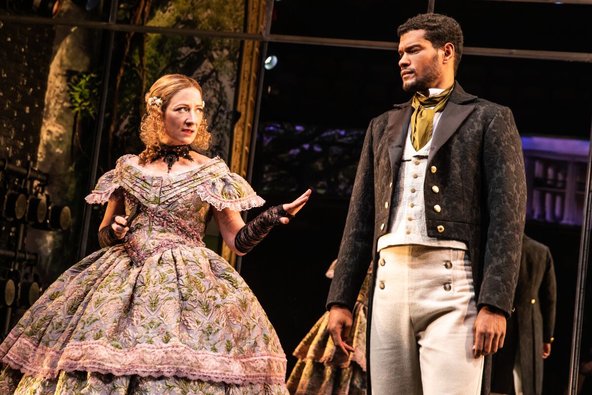Actors Annie McNamara and Sullivan Jones on stage in 19th century garb.