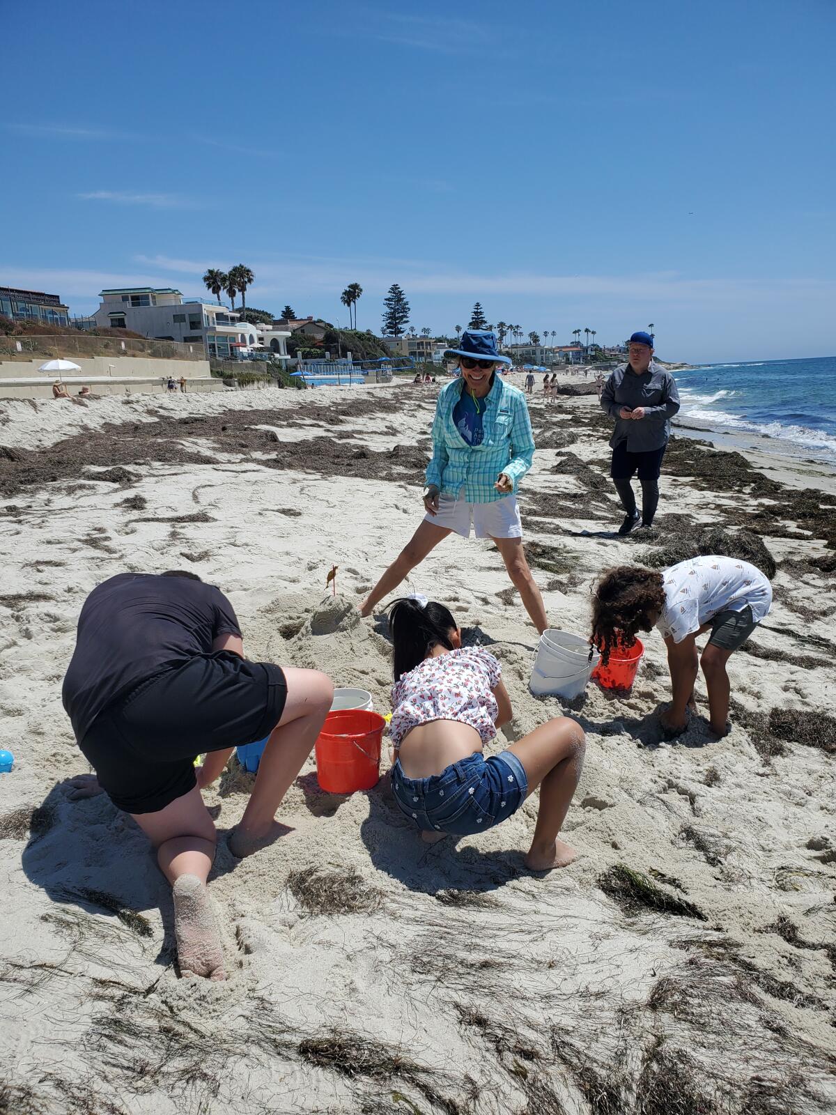 Judy and Dennis McNeely watch as children build a sandcastle on the beach behind the White Sands senior-living community.