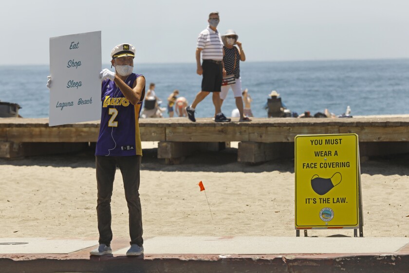 Laguna Beach self-appointed greeter, Michael Minutoli wears a mask while promoting the town.