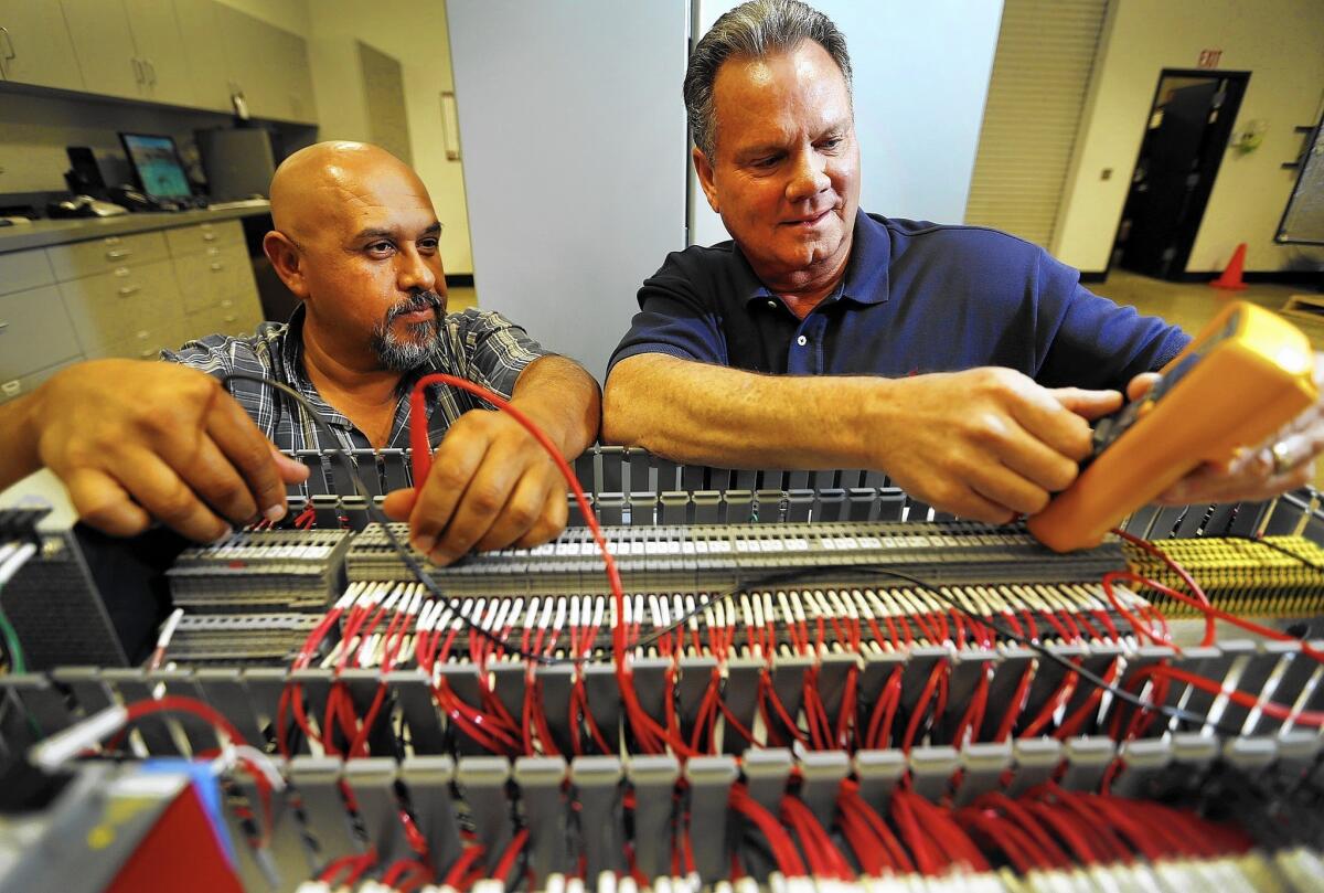 Don Nelson, right, president of ProGauge Technologies in Bakersfield, works with Joe Pena, a senior controls technician.