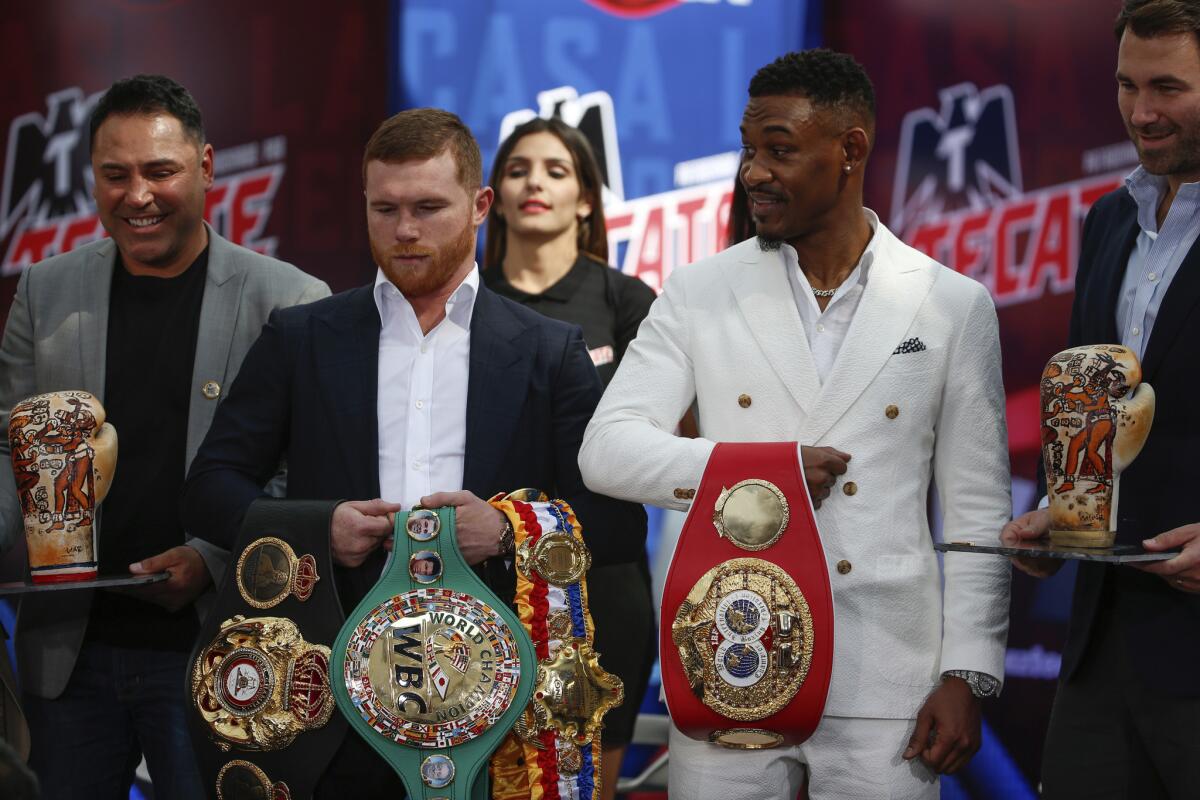 FILE - In this March 1, 2019, file photo, WBC and WBA middleweight world champion Canelo Alvarez, second from left, and IBF middleweight world champion Daniel Jacobs, second from right, pose with their title belts during a press conference in Mexico City. The moment won't be too big for Daniel Jacobs, of that he's certain. Not after going toe-to-toe with the fearsome Gennady Golovkin before dropping a narrow decision. Not after beating cancer that doctors were sure would end his career, if not his life. Canelo Alvarez will just be another obstacle in front of him when they meet Saturday night, May 4 in a middleweight title unification fight.