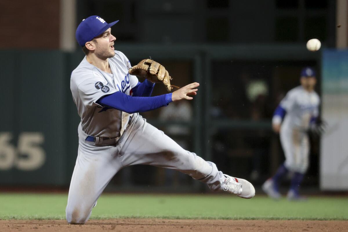 The Dodgers' Trea Turner tosses the ball.