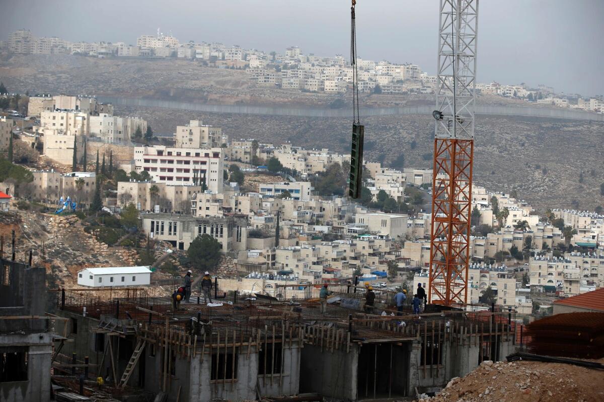 Construction crews work on housing in the Jewish settlement of Neve Yaakov, in the northern area of East Jerusalem, on Dec. 28.