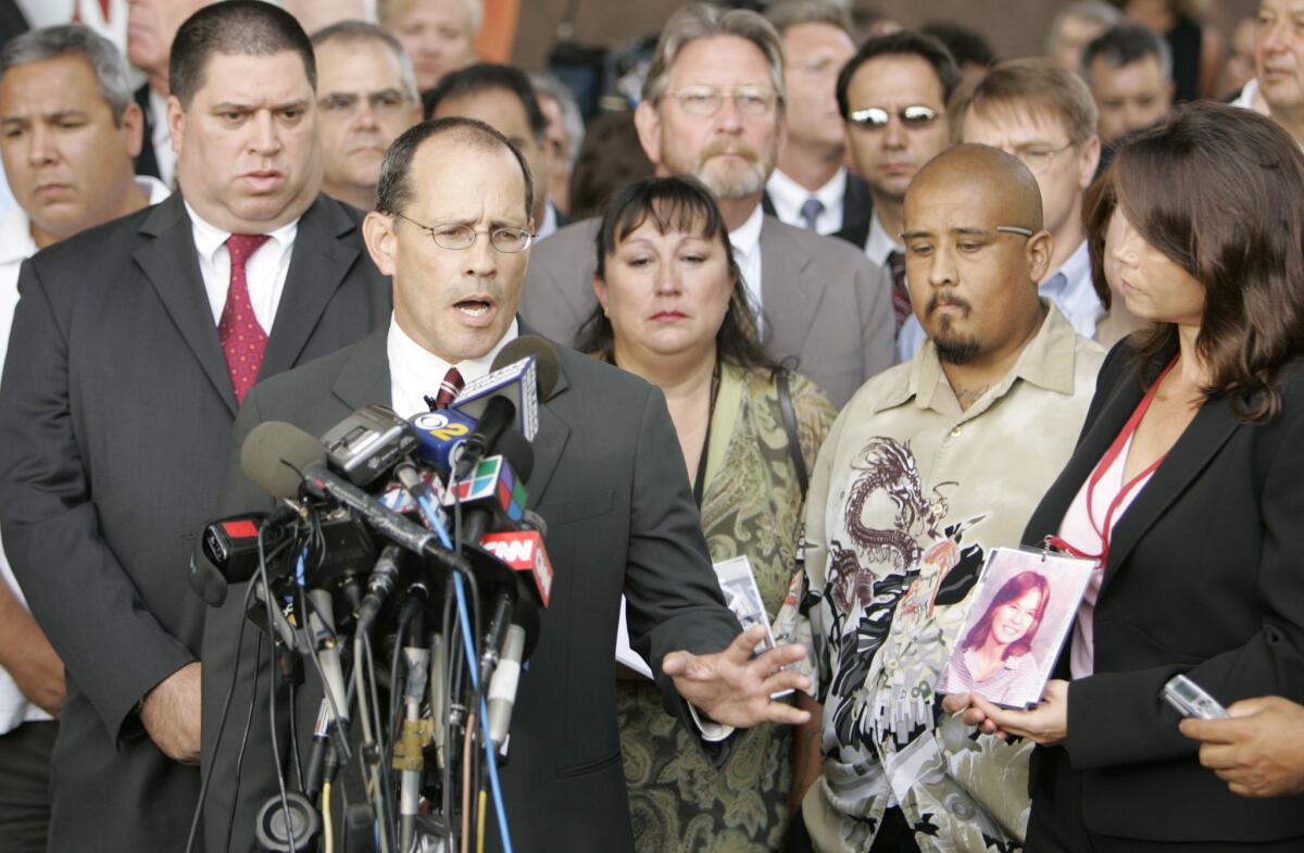 Attorney Ray Boucher is surrounded by plaintiffs as he addresses the media after the settlement.