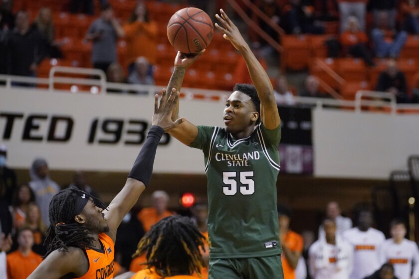 Cleveland State guard D'Moi Hodge (55) shoots over Oklahoma State guard Isaac Likekele, left, in overtime of an NCAA college basketball game Monday, Dec. 13, 2021, in Stillwater, Okla. (AP Photo/Sue Ogrocki)