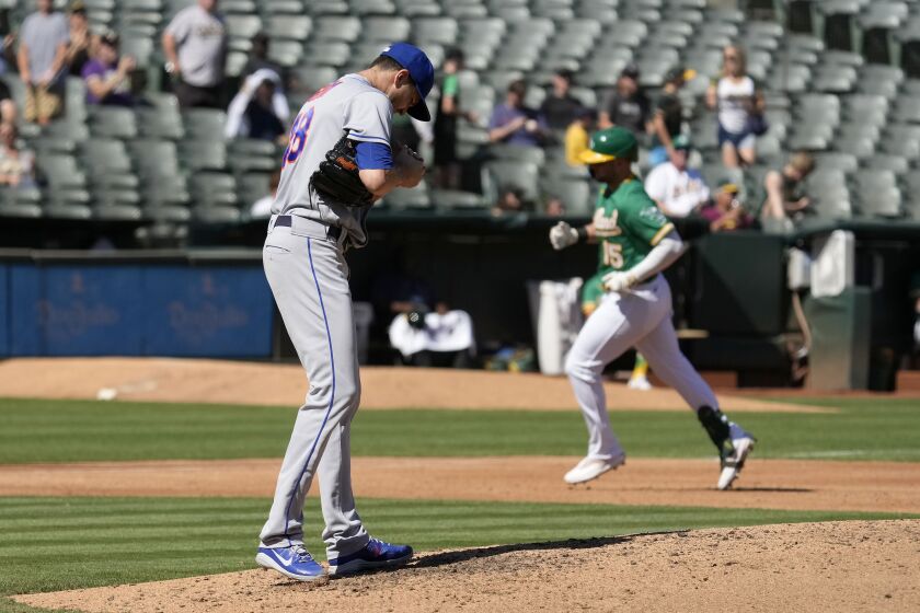 New York Mets starting pitcher Jacob deGrom, left, stands on the mound as Oakland Athletics' Seth Brown, right, rounds the bases after hitting a solo home run during the third inning of a baseball game in Oakland, Calif., Saturday, Sept. 24, 2022. (AP Photo/Tony Avelar)