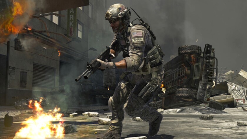 A gun-wielding soldier advances along a burning street in "Call of Duty: Modern Warfare 3."