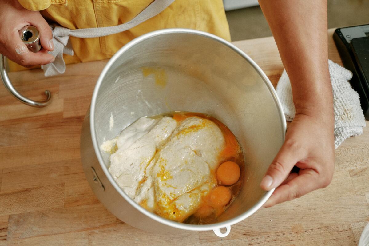 A mixing bowl containing the sponge mixture with zest, ground fennel and egg yolks for pan de muerto at Gusto Bread.