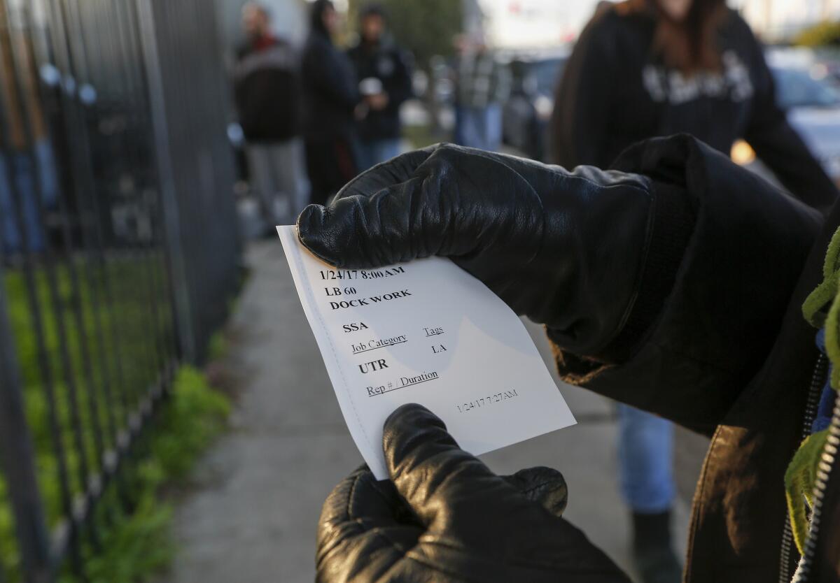 A worker shows a ticket with her assignment for the day. (Mark Boster / Los Angeles Times)