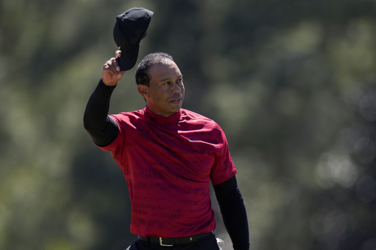 FILE - Tiger Woods tips his cap on the 18th green during the final round at the Masters golf tournament on Sunday, April 10, 2022, in Augusta, Ga. Tiger Woods returns to the Masters, no longer a surprise as it was a year ago but no less a rare appearance. (AP Photo/Jae C. Hong, File)