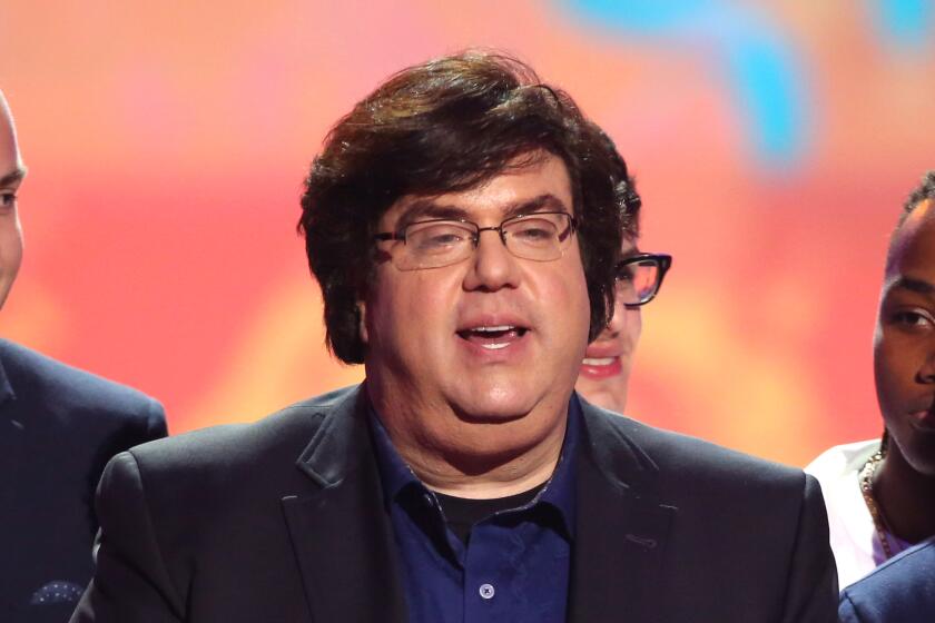 Dan Schneider at a microphone on stage.