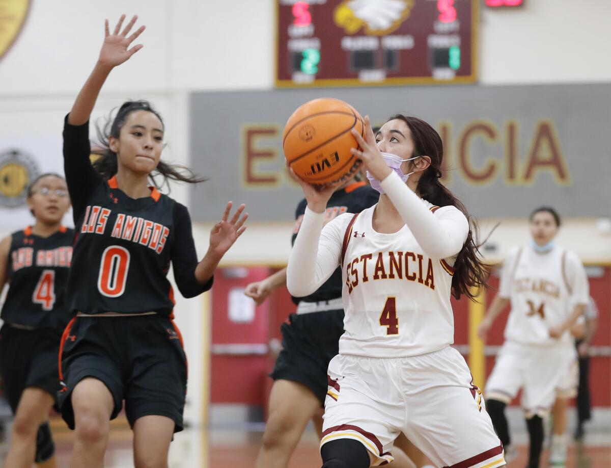 Estancia's Alexis Orellana takes a shot in front of Johanna Torrez during a basketball game against Los Amigos.