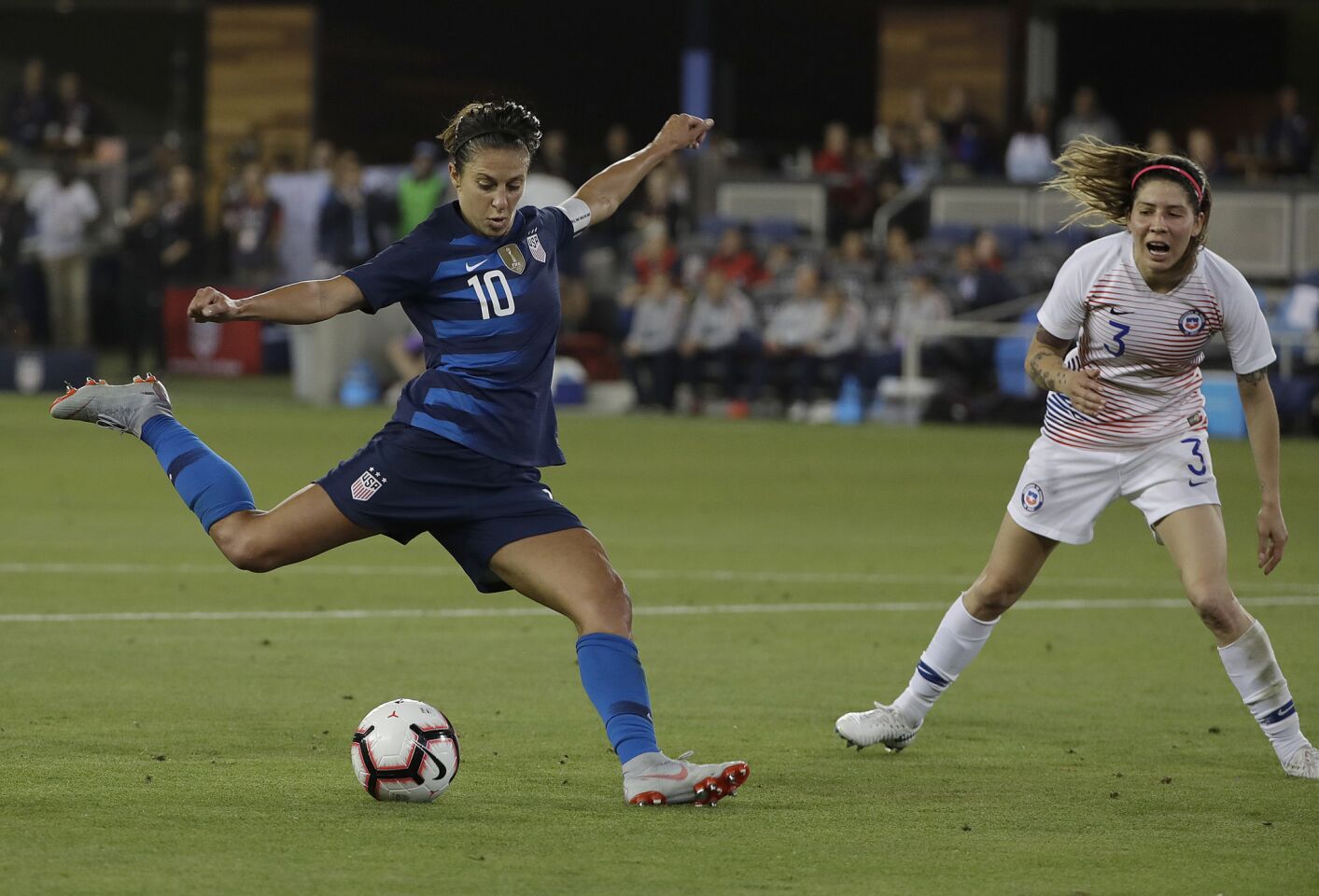 United States' Carli Lloyd (10) kicks the ball past Chile's Carla Guerrero to score a goal during the second half of an international friendly soccer match in San Jose, Calif., Tuesday, Sept. 4, 2018. (AP Photo/Jeff Chiu)