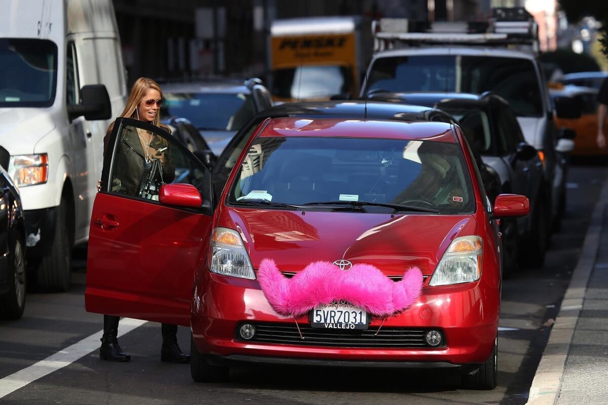 The ride-sharing services Uber and Lyft say that their expanded insurance coverage is aimed at addressing the concerns of state and local transportation regulators and answering criticism from the taxi industry. Above, a Lyft customer enters a car in San Francisco.