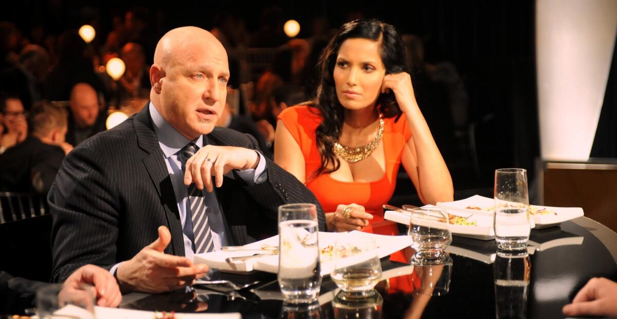 "Top Chef" judge Tom Colicchio lays some wisdom on a contestant while Padma Lakshmi looks on.