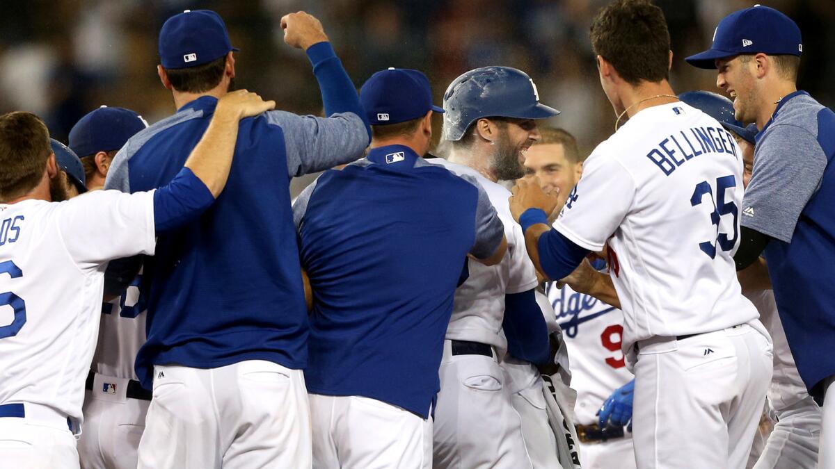 Chris Taylor, center, is mobbed by Dodgers teammates after delivering the game-winning hit against the Diamondbacks on Thursday night.