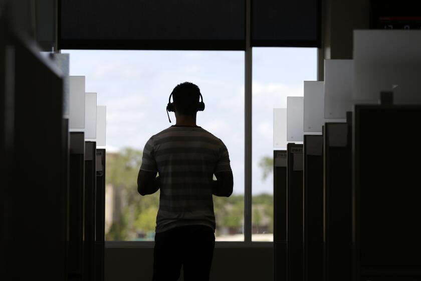 An advocate walks among cubicles at the National Domestic Violence Hotline center's new facility, Monday, June 27, 2016, in Austin, Texas. The center, which handles more that 1,000 calls, chats and texts per day, has doubled both its phone service stations and digital services stations. (AP Photo/Eric Gay)