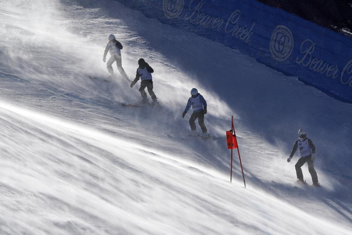 Course workers battle strong winds as they remove snow from the run before a men's World Cup downhill ski race Sunday, Dec. 5, 2021, in Beaver Creek, Colo. (AP Photo/Robert F. Bukaty)