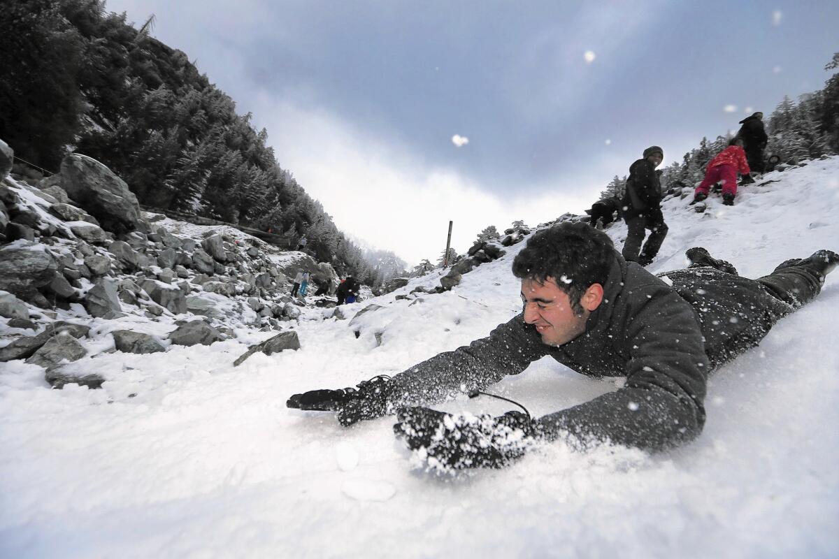 Steven DePaul, 17, of Chino slides on his stomach at Mt. Baldy after the area received a new mantle of snow.